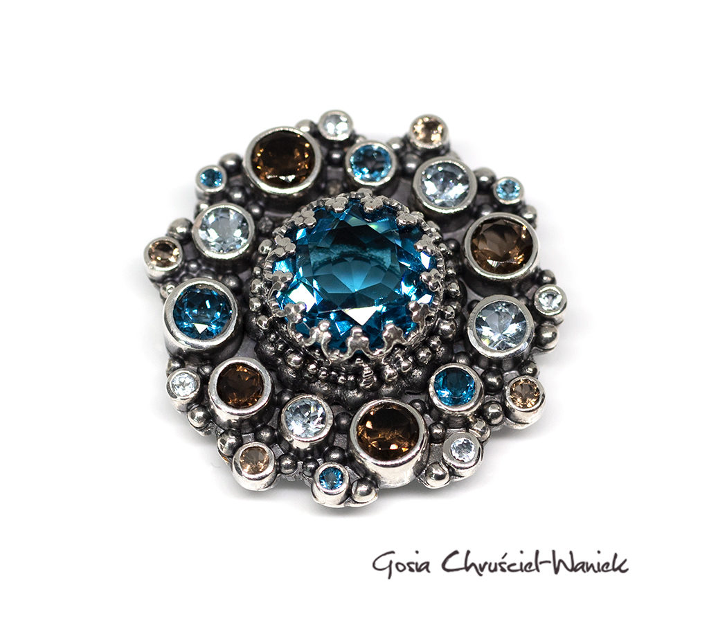 Efektowna broszka z topazami London Blue, akwamarynami i kwarcami dymnymi.